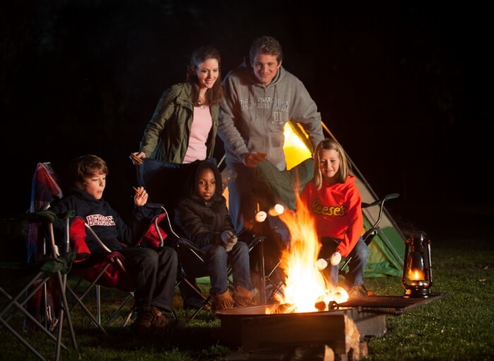 Family roasting marshmallows at Hersheypark Camping Resort