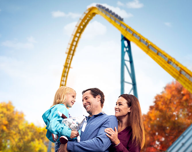 Family posing with rollercoaster in the background at Hersheypark