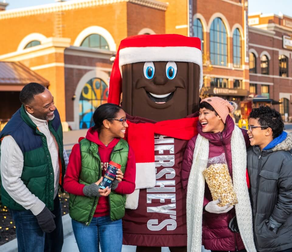 Family in front to Hersheypark Supply Co with Hershey character