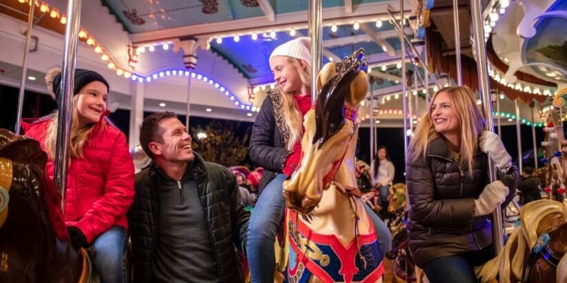 Family riding carrousel together at Hersheypark Christmas Candylane