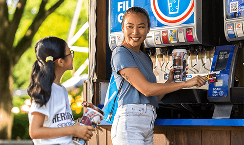 woman filling up a cup for child at Pepsi dispenser